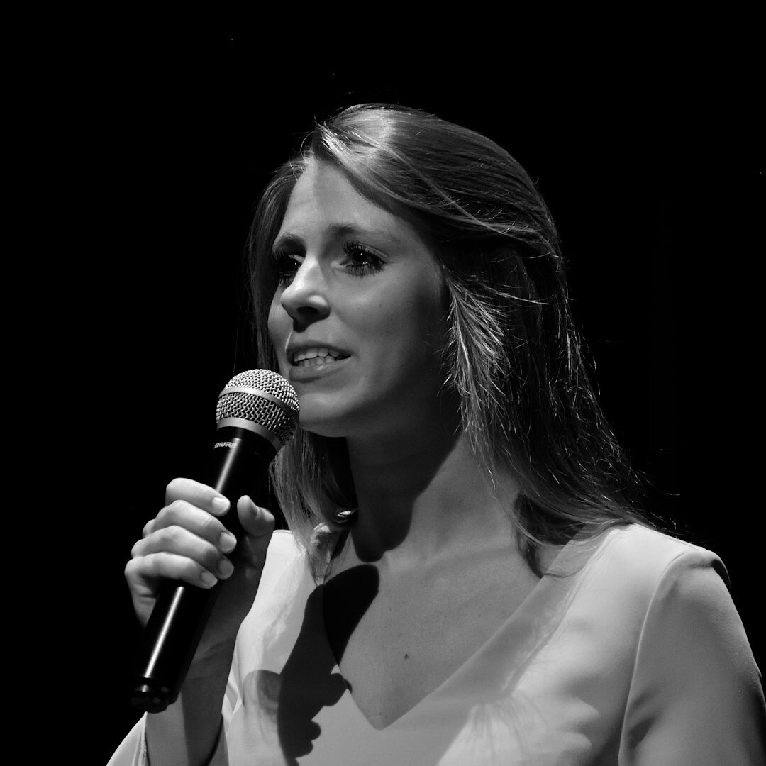 Woman journalist practising interview technique with microphone